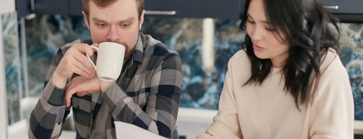 A couple researching debt settlement and reviewing their finances to determine if debt settlement is for them